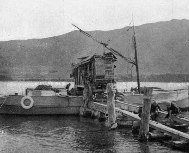 A threshing mill being loaded on to an oil launch at Pembroke, Lake Wanaka, to be taken to Mr...