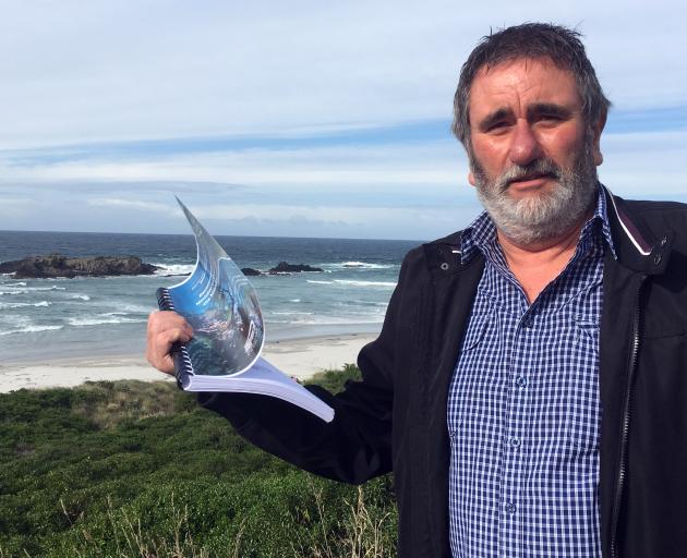 Tautuku Fishing Club president Brett Bensemann holds the South-East Marine Protection Forum recommendations near Smaills Beach, which is part of a proposed marine reserve. Photo: Shawn McAvinue