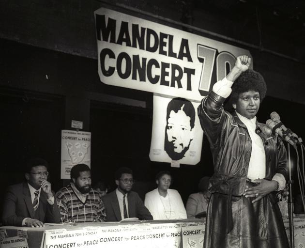 Winnie Mandela raises her fist in a black power salute after announcing that a massive pop...