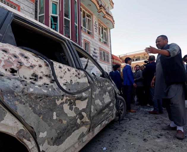 Afghan men inspect the site of a suicide bomb blast in Kabul, Afghanistan. Photo: Reuters