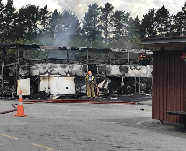 Firefighters inspect the bus after the fire. Photo: supplied
