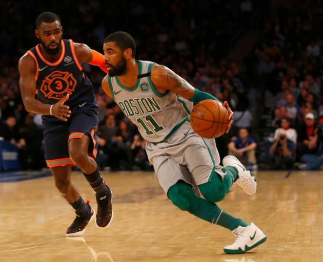 Boston Celtics guard Kyrie Irving (with ball) drives past New York Knicks' guard Tim Hardaway Jr...