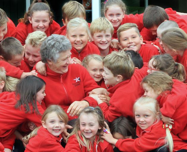 Five Forks School principal Cate Bole (65) is mobbed by pupils yesterday. Today she is retiring...