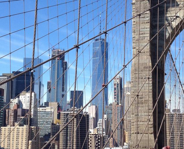 The One World Trade Centre tower (centre) looms above other skyscrapers in New York's financial district, as seen from the Brooklyn Bridge over the East River. Photo: HELEN SPEIRS