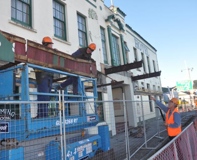 Grey District Mayor Tony Kokshoorn, right, instructs workmen at the Revingtons Hotel site this morning, with a tidy up he is paying for himself. Photo: Greymouth Star