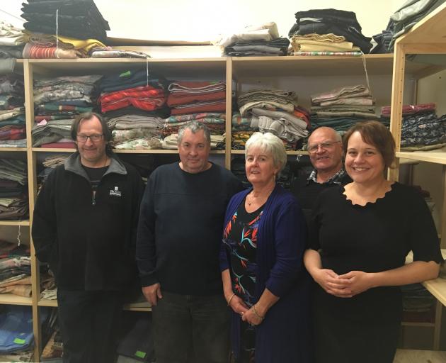 Dunedin Curtain Bank volunteers (from left) Ray Leckie, Steve Lynch, Marilyn Cook and Trevor Cook and manager Sara Crow stand with some of the donated curtains. PHOTO: Lucy McDonough