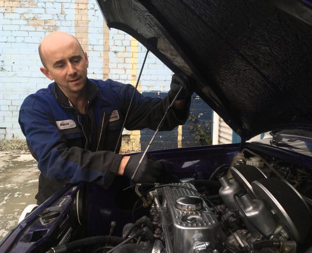 DNA Auto Services owner-operator Dave Atkins, of Mosgiel, checks the oil level of a Mini at his central Dunedin workshop.  PHOTO: SHAWN MCAVINUE