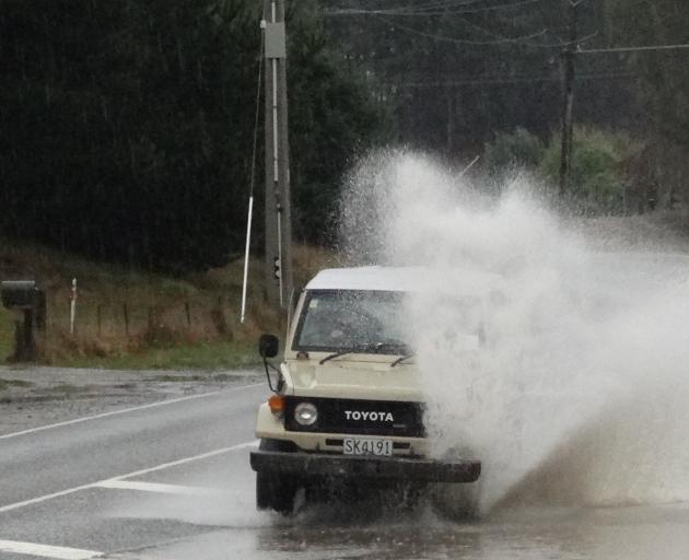 A motorist takes on surface flooding on Aubrey Rd in Wanaka today. Photo: Sean Nugent