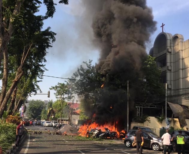 Motorcycles burn following a blast at the Pentecost Church Central Surabaya. Photo: Reuters