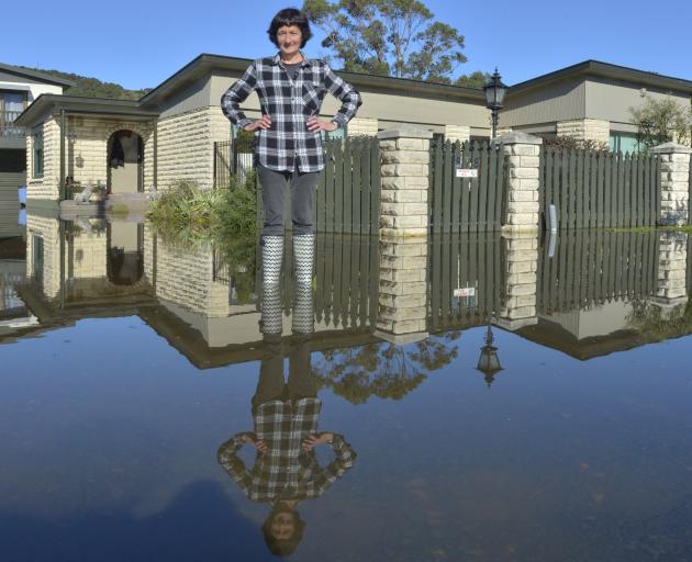 Harington Pt Rd woman Joan Burke outside her sister-in-law's property which flooded for the 10th...