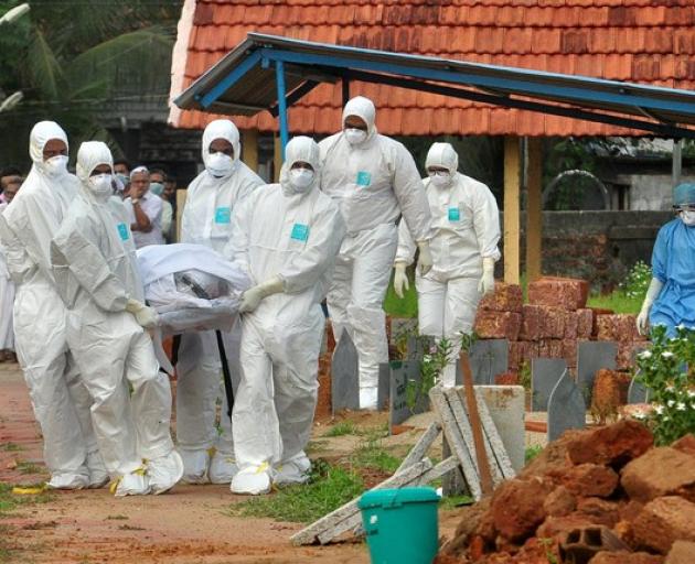 Doctors and relatives wearing protective gear carry the body of a victim, who lost his battle against the brain-damaging Nipah virus. Photo: Reuters