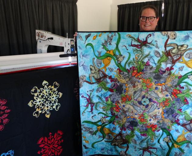 Weston-based quilter Mathea Daunheimer shows an example of a large quilt she has just completed...