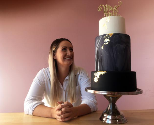 Williams & Co Kitchen Ltd owner Tess Williams inspects a wedding cake in her new shop in Mornington. Photo: Shawn McAvinue