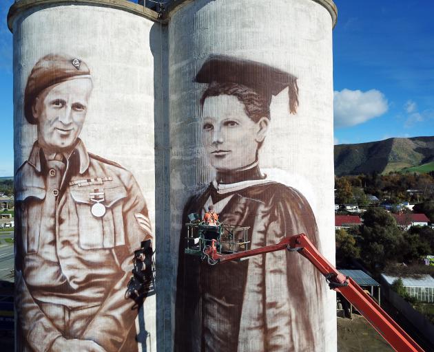 Waimate artist Bill Scott works on murals on grain silos at Transport Waimate's Queens St yard. The murals are of Waimate-born World War 2 soldier Eric Batchelor and New Zealand's first woman to be registered as a doctor, Margaret Cruickshank, who practis