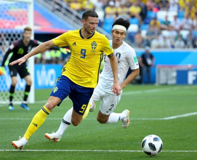 Marcus Berg controls the ball for Sweden as Lee Yong comes across to contest for Korea. Photo:...