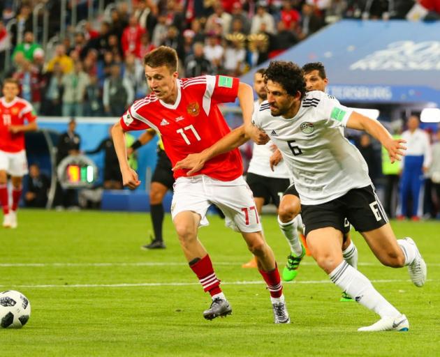 Aleksandr Golovin of Russia competes with Ahmed Hegazy of Egypt during their World Cup game this...