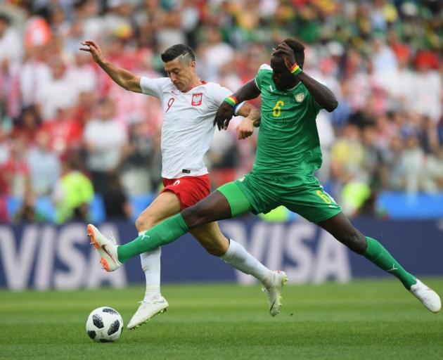 Robert Lewandowski of Poland is challenged by Salif Sane of Senegal in their World Cup game this...