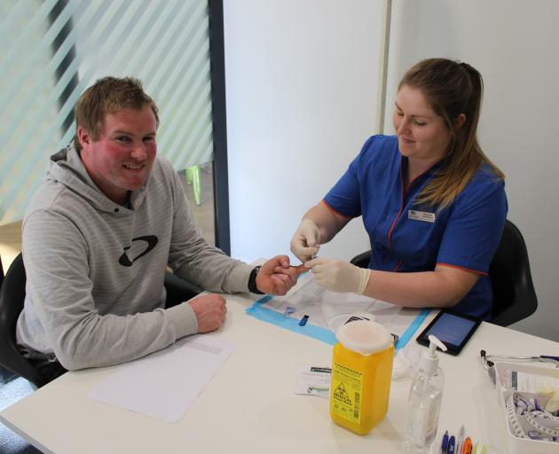 Gore dairy farmer Simon Vallely has his finger pricked by Southern Institute of Technology nursing student Sophie Johnson as part of DairyNZ's Health PitStop in Gore recently. Photo: Nicole Sharp