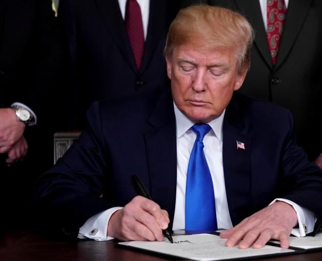 US President Donald Trump signs a memorandum on intellectual property tariffs on high-tech goods...