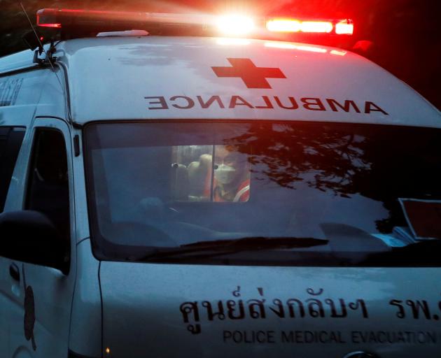 A rescue worker is seen in an ambulance believed to be carrying rescued schoolboys travels to a...