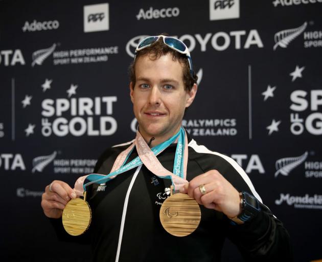 Otago skier Adam Hall at Auckland Airport yesterday with the gold and bronze medals he won at the Winter Paralympics in South Korea. Photo: Getty Images