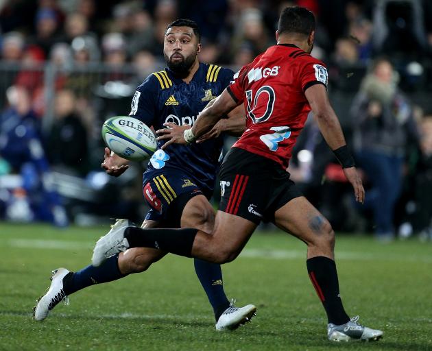 Highlanders first five-eighth Lima Sopoaga slips a pass behind the back of his Crusaders...