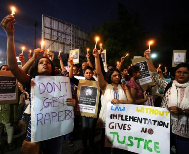 Women hold candles as they shout slogans during a protest against the rape of a ten-year-old girl, in the outskirts of Delhi. Photo: Reuters