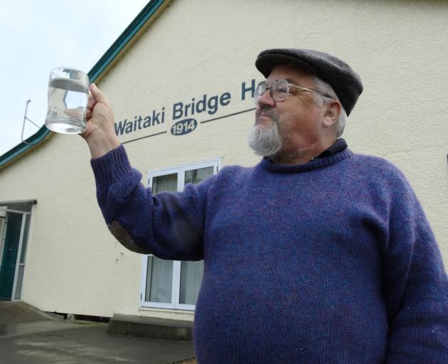 Waitaki Bridge Village resident Peter Whitlock holds a glass of water from his tap. He says the...