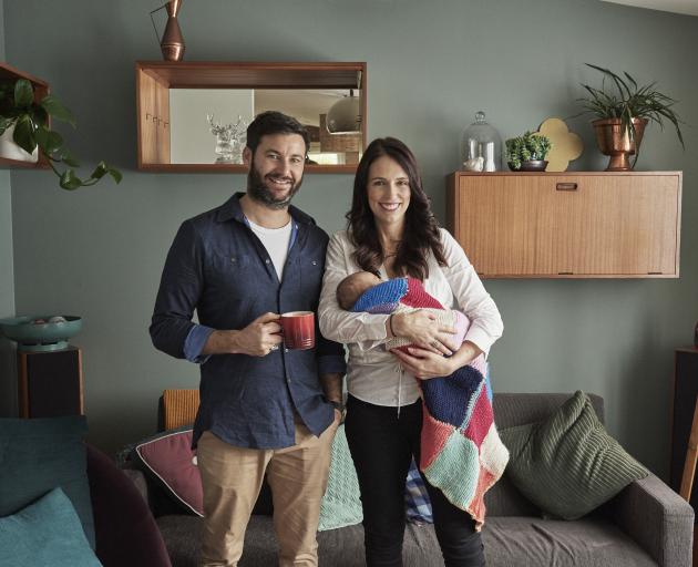 Prime Minister Jacinda Ardern and partner Clarke Gayford relax in the living room of their Auckland home with baby Neve. Photo: Derek Henderson