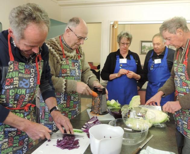 Senior chefs chop and grate vegetables for coleslaw. At rear are Pip Weber and  Craig McLanachan. Photo: Supplied