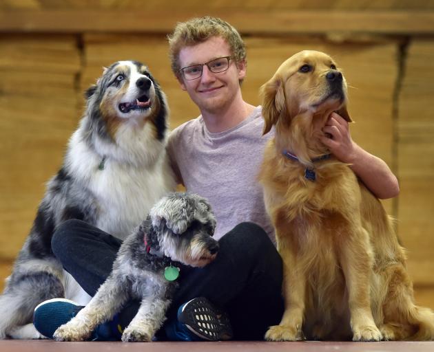 University of Otago student Finnbar Grieve (19) chills with friendly dogs (from left) Martin, ...