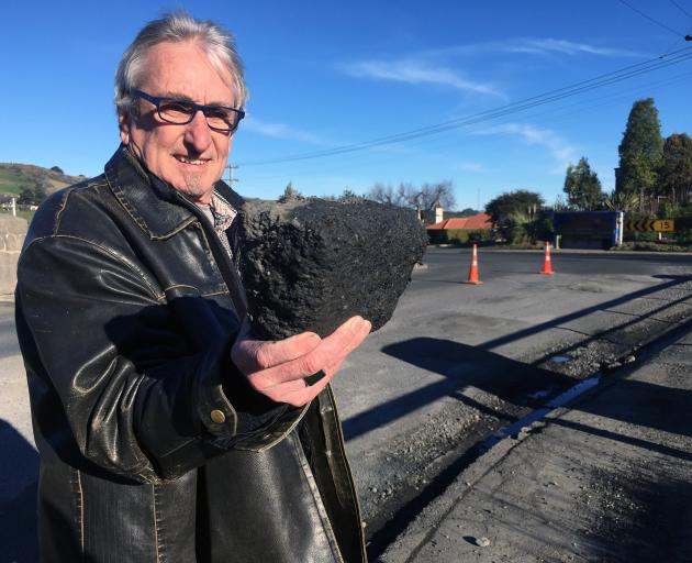 Rob Fitzpatrick inspects a chunk of asphalt left behind after a temporary repair of a bridge deck in Abbotsford. Photo: Shawn McAvinue