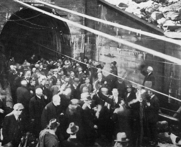 The cheering crowd at the entrance to the Otira tunnel as the last charge is set off to pierce the remaining rock. - Otago Witness, 28.8.1918. 