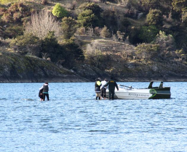Rescuers help people on a jet-boat which hit a sandbar at Homestead Bay at the mouth of the...