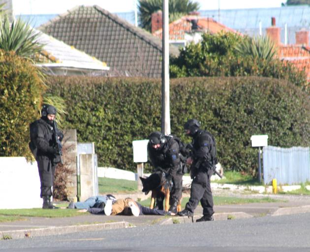 Members of the armed offenders squad deal with two men in Miller St, Invercargill on Monday, when...
