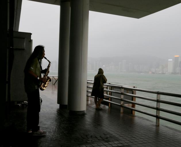 A man plays music as Typhoon Mangkhut approaches Hong Kong. Photo: Reuters