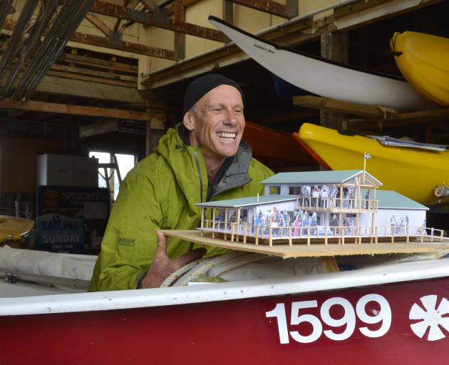 Broad Bay Boating Club rebuild committee member Chris Charteris-Wright shows off a model of the club's planned redevelopment, inside the club's now inadequate boat storage facility. Photos: Gerard O'Brien