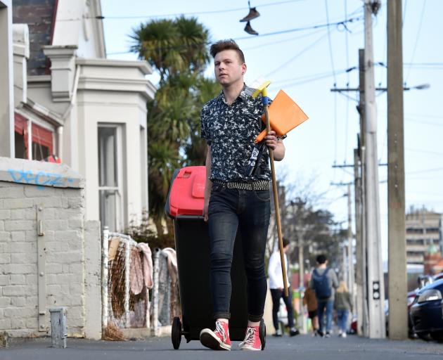 Matthew Schep, co-leader of Students for Environmental Action, helps collect rubbish in Castle St...