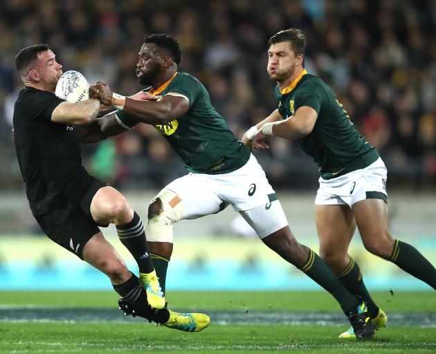 Ryan Crotty is knocked over by a brilliant South Africa defence. Photo: Getty Images