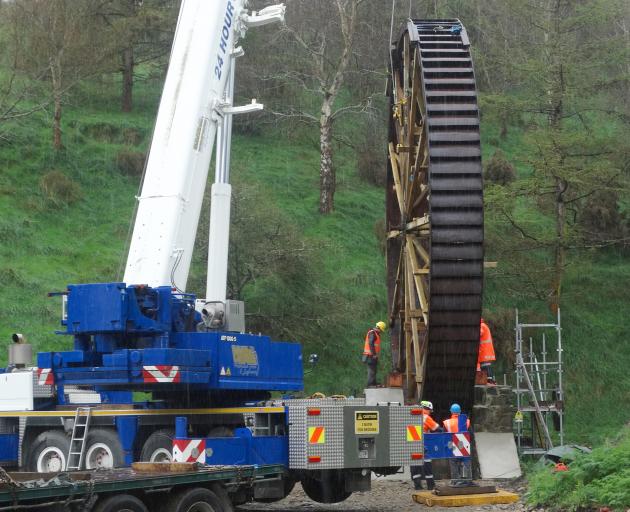 The newly-restored historic Phoenix Mill water wheel is lifted into place at its original site in Old Mill Rd west of Oamaru yesterday. Photo: Daniel Birchfield