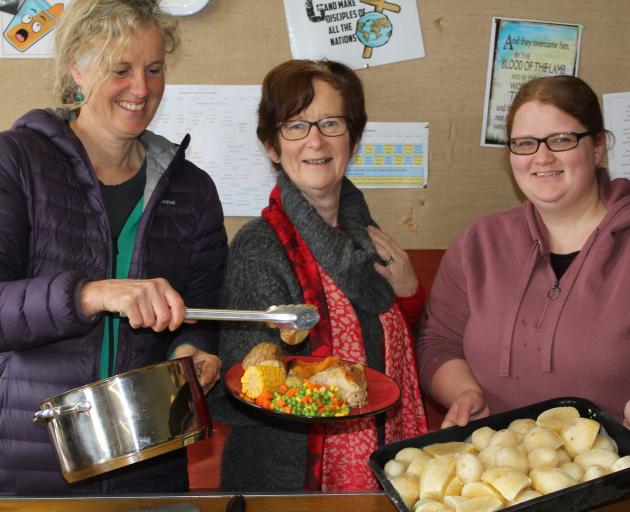 The Hub free meals team (from left) Pip Gardyne, Heather Gullick and Sarah Cowan dish up a hot meal for migrant farm workers. Photo: Margaret Phillips