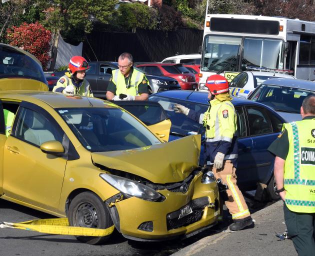 Emergency services prepare to pull a Mazda Demio out of the way so a woman (obscured) trapped between it and the Ford Focus (behind), can be removed. She was caught for more than 30 minutes before being extricated and taken to Dunedin Hospital in a modera