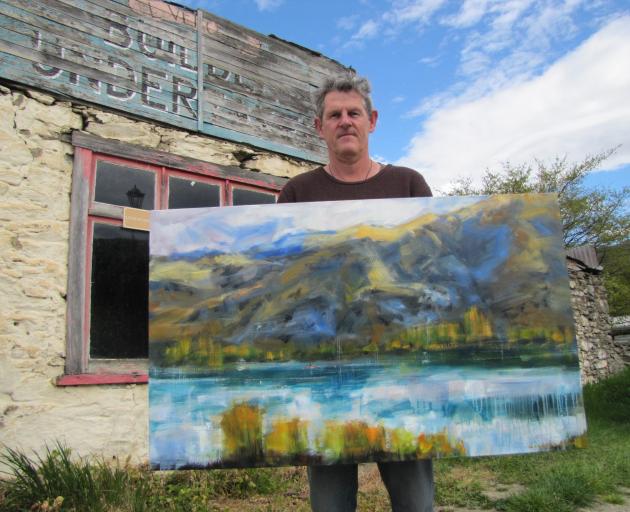 Central Otago Art Society president Nigel Wilson displays one of his artworks before the...