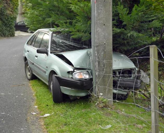 The power authority, police, a tow truck and traffic management were involved after this abandoned car was discovered crashed into a power pole in Aitken Place this morning. Photo: Stephen Jaquiery