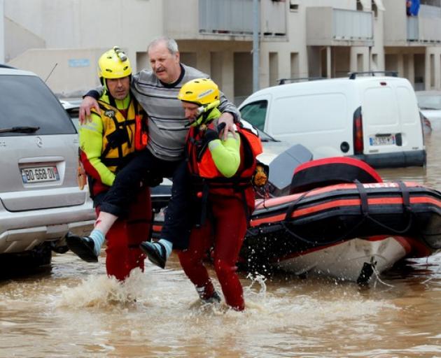 Rescue workers evacuate residents from a neighbourhood after flash floods hit the southwestern Aude district of France after several months' worth of rain fell in just a few hours overnight. Photo: Reuters