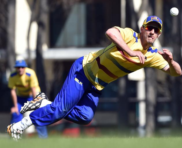 Otago opening batsman Hamish Rutherford dives to catch the ball during a training session at...