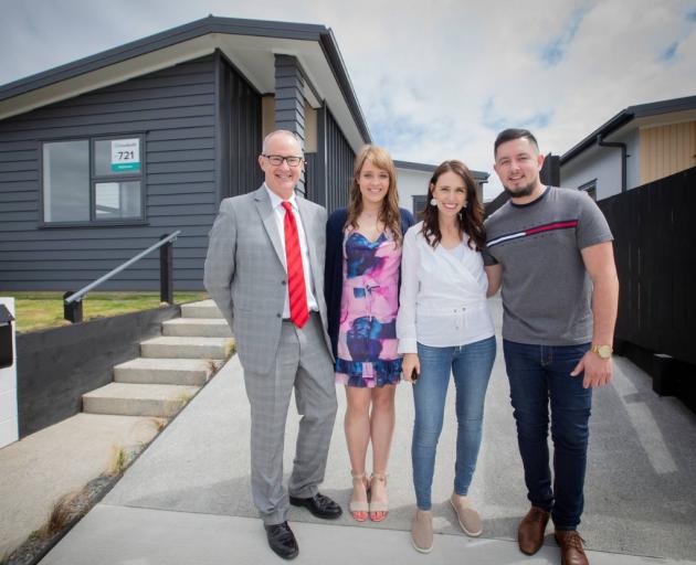 Phil Twyford and new KiwiBuild homeowners Derryn Jayne and Fletcher Ross stand with PM Jacinda...