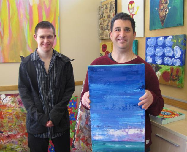 Living Options artists Logan Winter (left) and Andrew Wallace display some of the work that will feature in the Living Options Alexandra Thyme Festival exhibition. Mr Winter will exhibit the yellow painting that is behind him, and Mr Wallace will exhibit