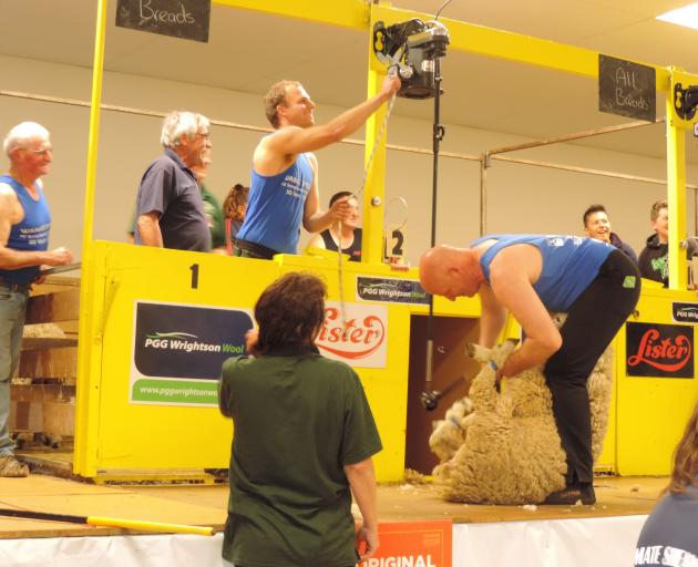 Jack Fagan switches on the shearing machine for his father, Sir David Fagan, halfway through the Waimate Shears "father and son" event. Photo: Sally Brooker