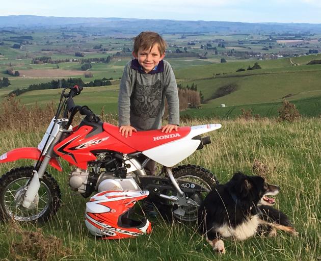 Ollie Paterson (8) with his motorbike, Emmie Paterson (6) inspects some sheep with Brian the dog, and Jimmy Paterson (4) also checks out some sheep. Photo: Paterson family